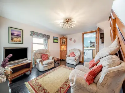 a living room with two chairs and a television at The Stables - Uk37415 in Bunessan