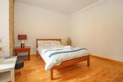 a bedroom with a bed and a wooden floor at Deluxe Apartment in Lanark