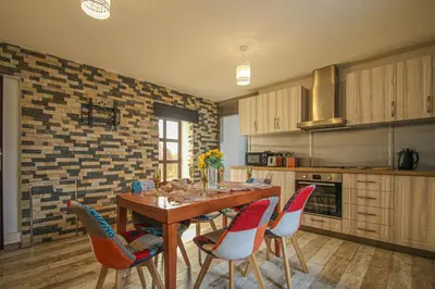 a kitchen with a wooden table and chairs at Deluxe Apartment in Lanark