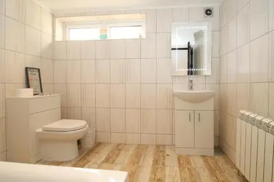 a bathroom with a toilet and a sink and a mirror at Deluxe Apartment in Lanark