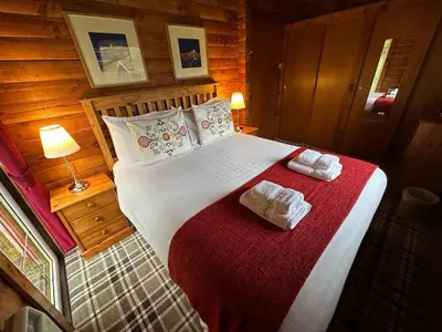 a bedroom with a large bed with towels on it at Pucks Glen Lodges - Cosy Lodges in a Woodland Setting in Dunoon