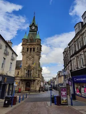 a building with a clock tower in the middle of a street at Fabulous 2BD Maisonette Dunfermline, Fife in Dunfermline