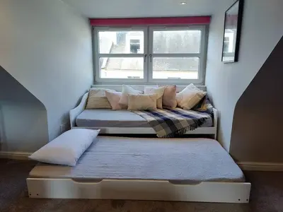 two beds in a room with a window at Fabulous 2BD Maisonette Dunfermline, Fife in Dunfermline