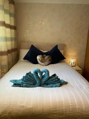 two towels on a bed with a donut and a pillow at Dunfermline, 2 bedroom home free on street parking in Fife