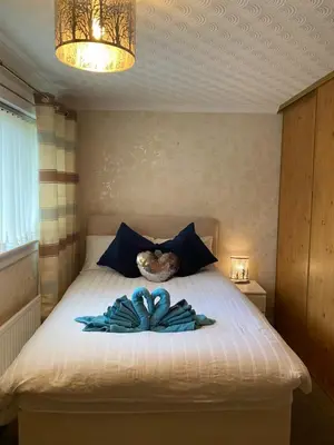 a bedroom with a bed with a blue bow on it at Dunfermline, 2 bedroom home free on street parking in Fife