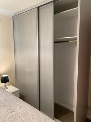 a bedroom with sliding closet doors with a bed at Dunfermline, 2 bedroom home free on street parking in Fife