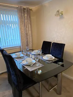 a dining room table with plates and glasses on it at Dunfermline, 2 bedroom home free on street parking in Fife