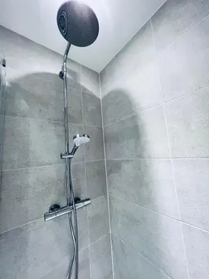 a shower with a shower head in a bathroom at DESIGNER HOUSE - University of Glasgow / Central Glasgow 'Hillhead' West End G12 - Luxurious & Contemporary Detached House / Terrace / Garden / 'electric car charging' Garage Parking in Glasgow