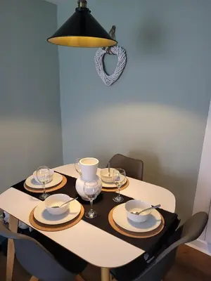 a dining room table with plates and wine glasses at The Bailey - Troon - Coorie Doon Stays in Troon