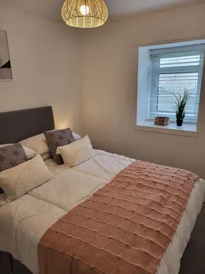 a bedroom with a large bed with a window at The Bailey - Troon - Coorie Doon Stays in Troon