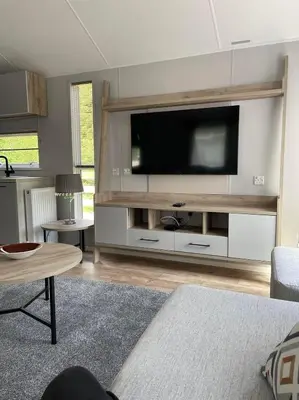 a living room with a large television on a wall at The Astoria 41 in Dunoon