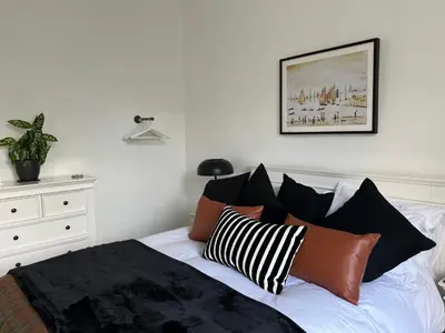 a bedroom with a bed with black and white pillows at The Lowry .. Where elegance meets Luxury! in Oban