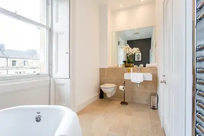 a bathroom with a tub and a toilet and a window at Exclusive 2 Bed, Free Private Parking, in West End in Edinburgh