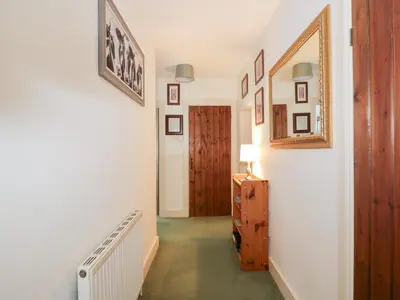 a hallway with a door and a dresser in a room at Strathannan in Moffat