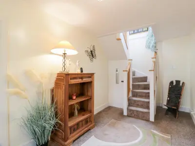 a living room with a staircase and a lamp at Strathannan in Moffat
