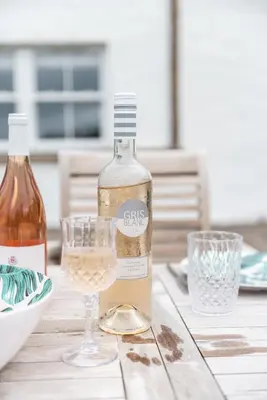 a bottle of wine and a glass on a table at Steading Cottage - 50m from the beach in Port Appin