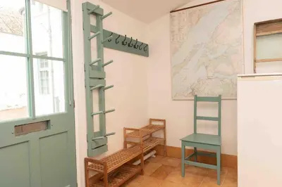 a room with a door and a chair and a map at Steading Cottage - 50m from the beach in Port Appin