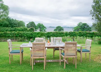 a wooden table with four chairs and a table and chairsktop at Steading Cottage - 50m from the beach in Port Appin