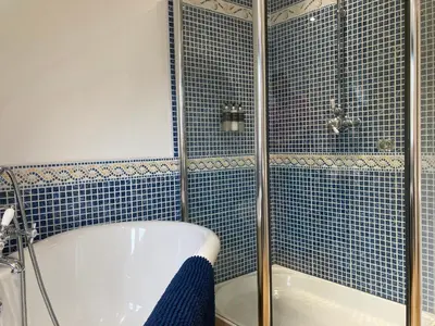 a blue tiled bathroom with a tub and a shower at Craigneuk near Oban, stunning home with sea views in Oban