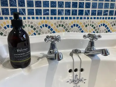 a bottle of wine sitting in a bathroom sink at Craigneuk near Oban, stunning home with sea views in Oban