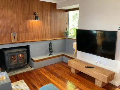 a living room with a large television and a fireplace at Craigneuk near Oban, stunning home with sea views in Oban