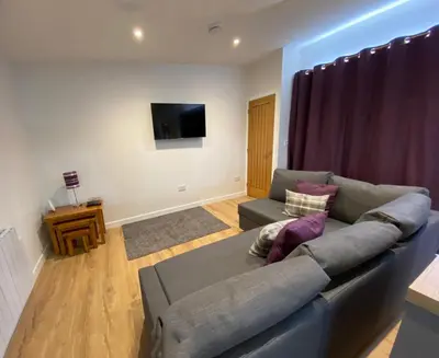 a living room with a couch and a tv at White Cottage - Cosy Holiday Cottage in Drymen, Loch Lomond & Trossachs in Drymen
