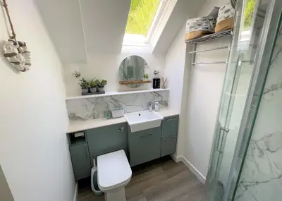 a bathroom with a toilet and a sink and a window at Coorie Doon in Cairnbaan