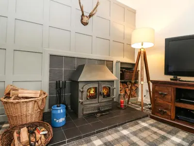 a living room with a fireplace and a television at Ben Grianan in Aberfeldy