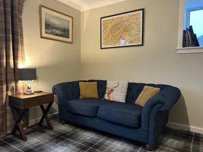 a blue couch in a living room with a table at Ben Grianan in Aberfeldy