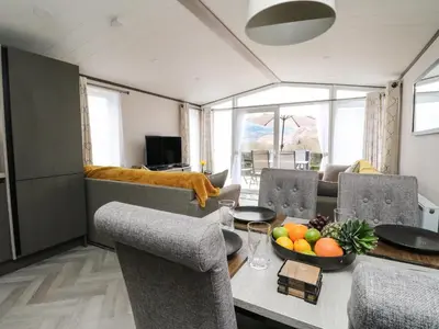 a living room with a table with a bowl of fruit on it at Red Kite Lodge in Crieff