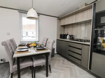 a kitchen with a table and chairs and a stove at Red Kite Lodge in Crieff