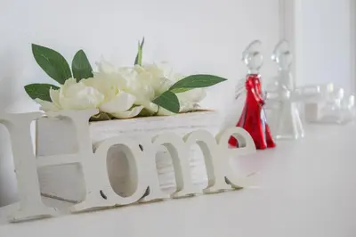 a wooden sign that says love with a vase of flowers at Tinto View Apartment in Carstairs