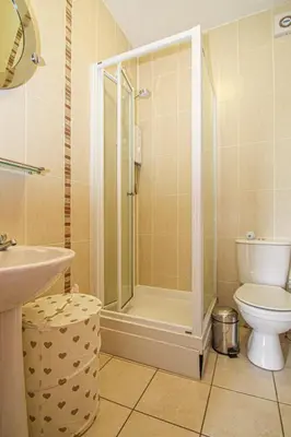 a bathroom with a shower and a toilet and a sink at Tinto View Apartment in Carstairs