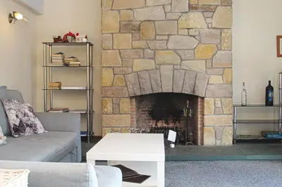 a living room with a stone fireplace at Tinto View Apartment in Carstairs