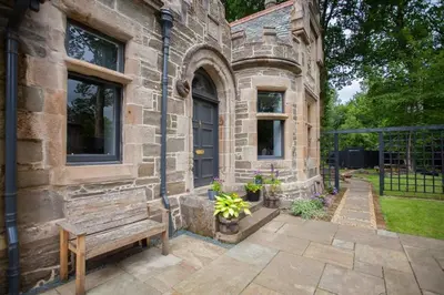 a stone building with a bench in front of it at Stylish Loch Lomond lodge in stunning surroundings in Balloch