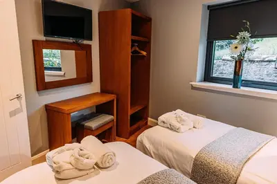 a small room with two beds and a mirror at Stylish Loch Lomond lodge in stunning surroundings in Balloch