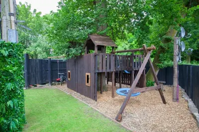 a playground with a slide and a playset at Stylish Loch Lomond lodge in stunning surroundings in Balloch