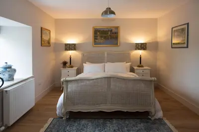 a bedroom with a white bed with two night stands at Laverockbank Steading in Buchanty
