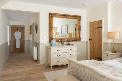 a bedroom with a mirror and a bed and a dresser at Laverockbank Steading in Buchanty
