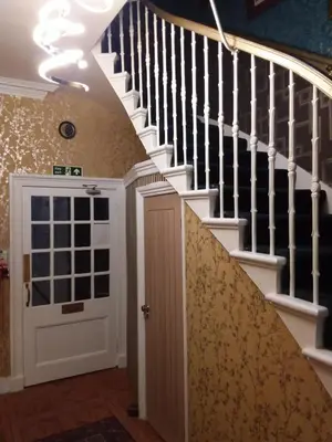 a hallway with a staircase with a door and a stair case at IVY House in Edinburgh