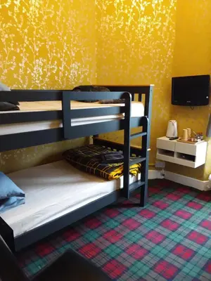 two bunk beds in a room with a yellow wall at IVY House in Edinburgh