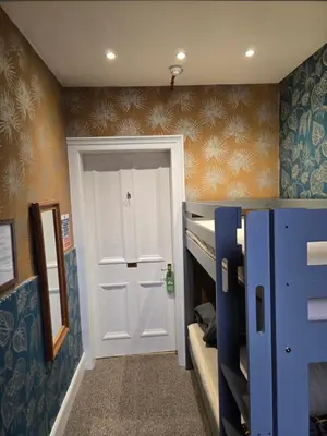 a room with a door and a room with bunk beds at IVY House in Edinburgh