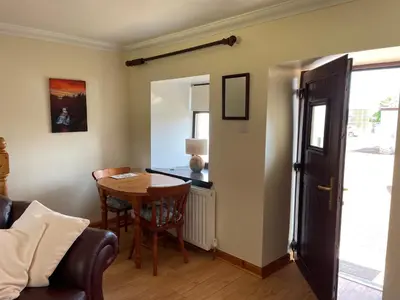 a dining room with a table and a chair at Corehouse Farm Cottages - Dairy, Granary & Sawmill in Lanark
