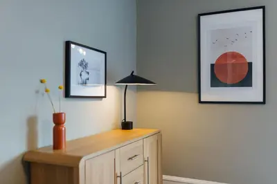 a lamp on top of a wooden dresser in a room at The Riverside Apartment (free parking) in Stirling