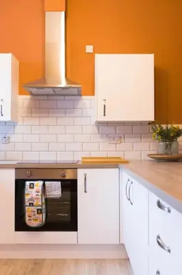 a kitchen with white cabinets and an oven at The Riverside Apartment (free parking) in Stirling