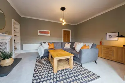 a living room with a couch and a table at The Riverside Apartment (free parking) in Stirling