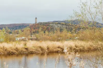 a body of water with a hill in the background at The Riverside Apartment (free parking) in Stirling
