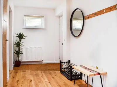a hallway with a mirror and a table at Rubys Cottage in Crieff