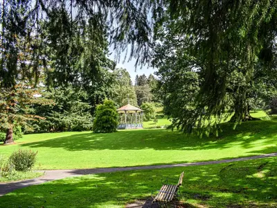 a park with a bench and a gazebo in the grass at Rubys Cottage in Crieff