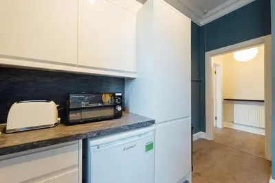 a kitchen with a counter with a toaster and a microwave at Stylish Stirling Apartment - free parking in Stirling